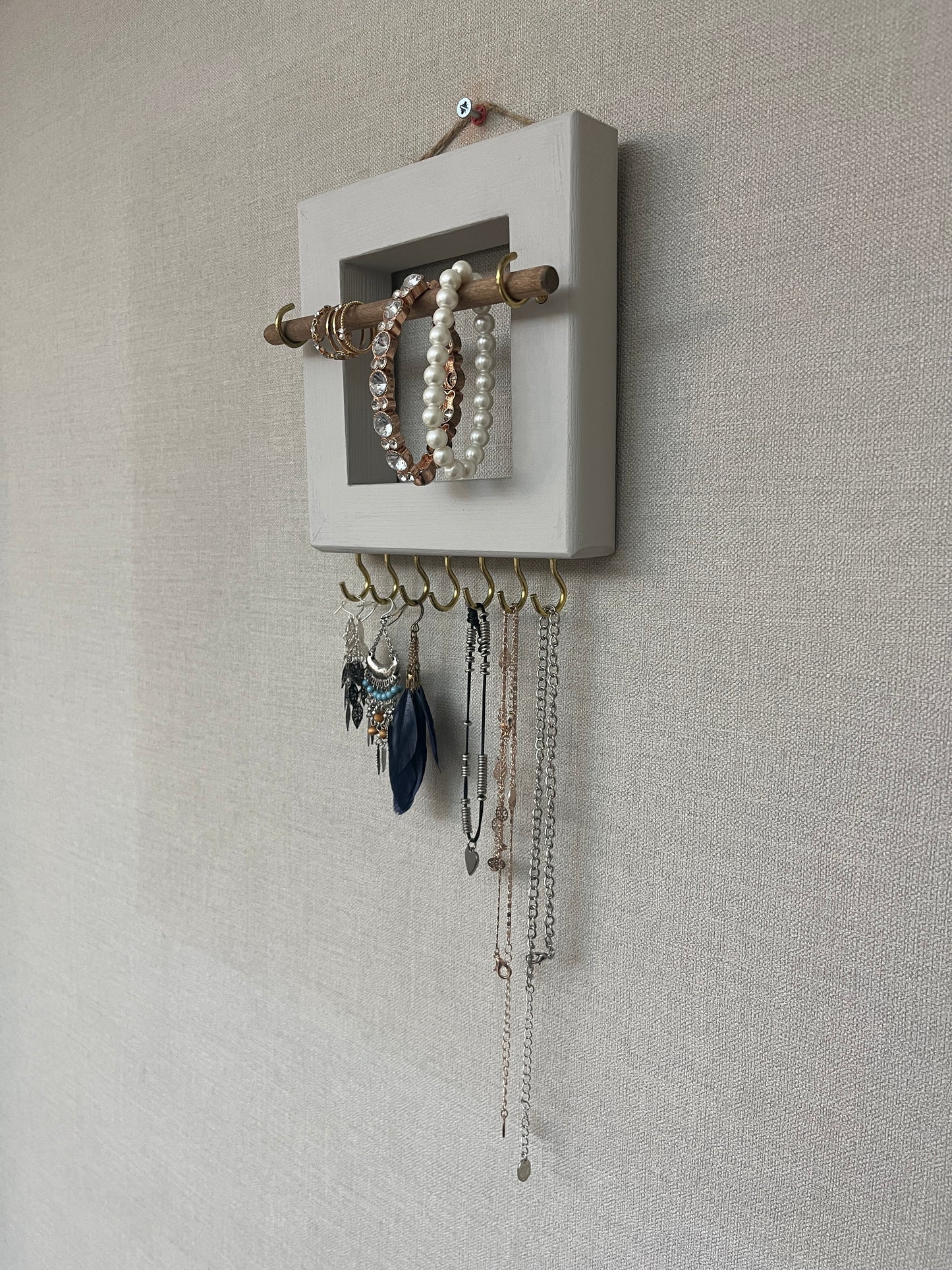 Handmade premium jewellery organizer crafted from timber, with hooks and a storage rod to safely store rings, necklaces, earrings, and bracelets. Available in 3 sizes. Frame design for wall mounting with D rings. Customizable color.