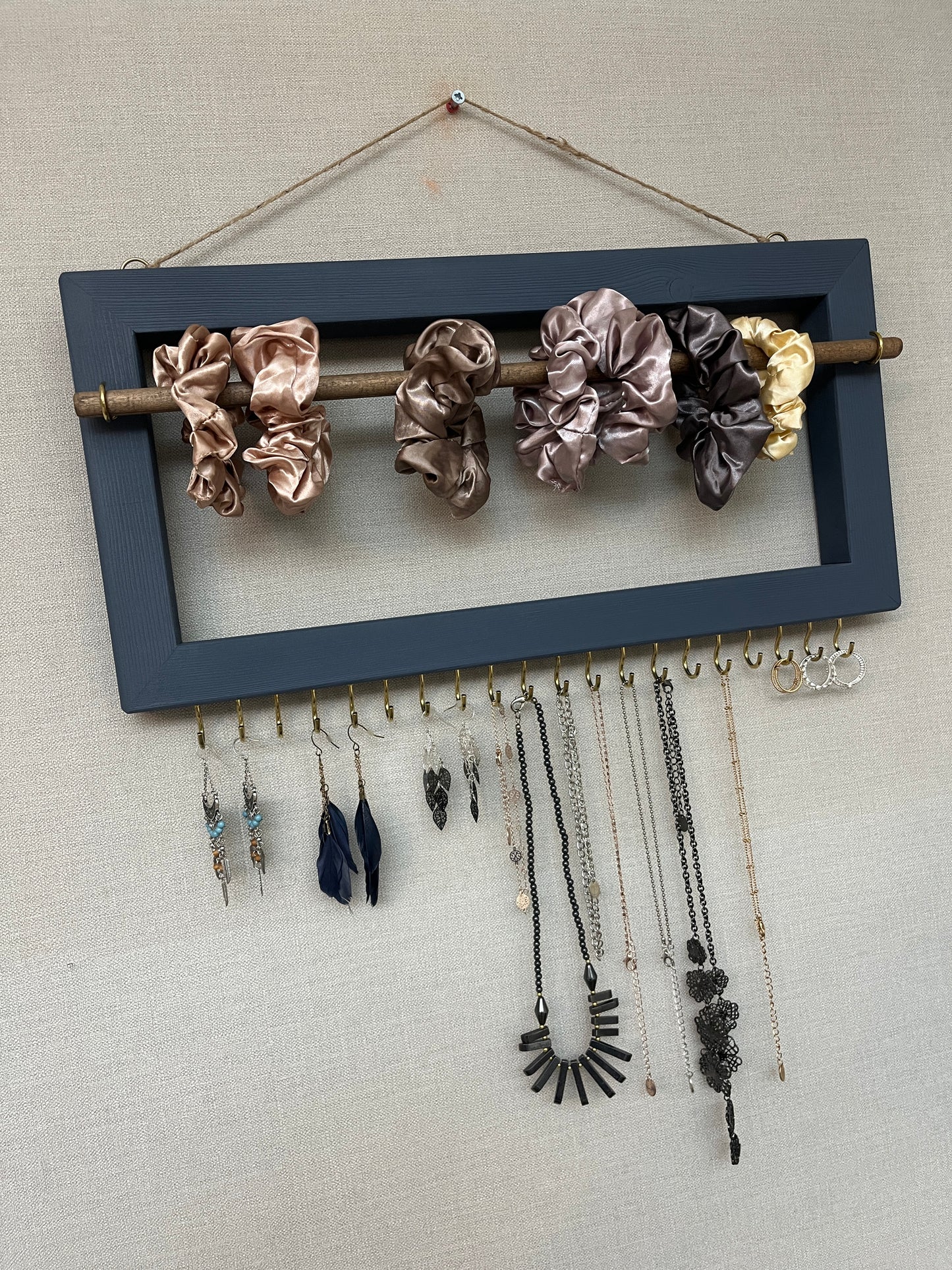 Handmade premium jewellery organizer crafted from timber, with hooks and a storage rod to safely store rings, necklaces, earrings, and bracelets. Available in 3 sizes. Frame design for wall mounting with D rings. Customizable color.
