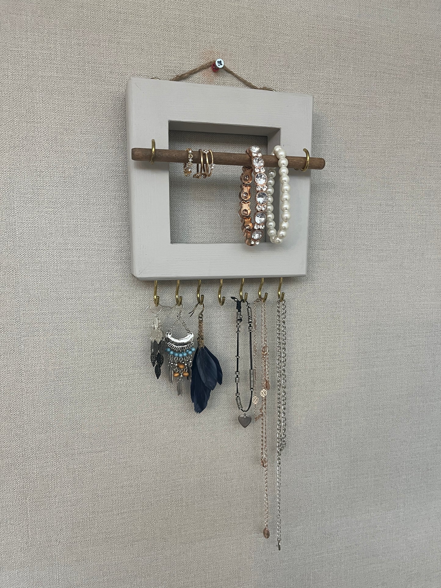 Handmade premium jewellery organizer crafted from timber, with hooks and a storage rod to safely store rings, necklaces, earrings, and bracelets. Available in 3 sizes. Frame design for wall mounting with D rings. Customizable color.