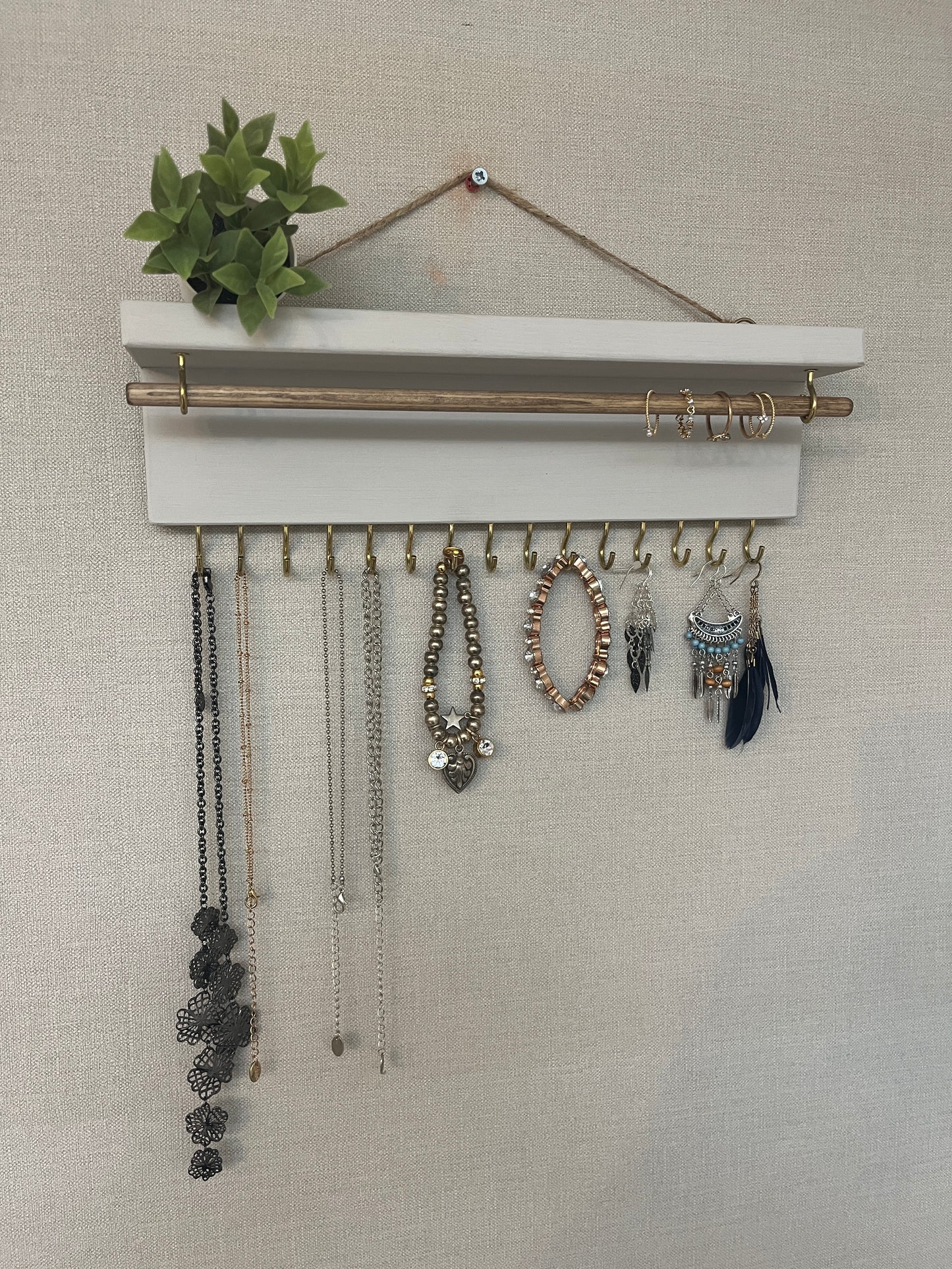 Handmade premium jewellery organizer crafted from timber, featuring 15 hooks for rings, necklaces, earrings, and bracelets. Top shelf for small items. Compact design, easy to hang, customizable color. Perfect gift for fashion lovers.