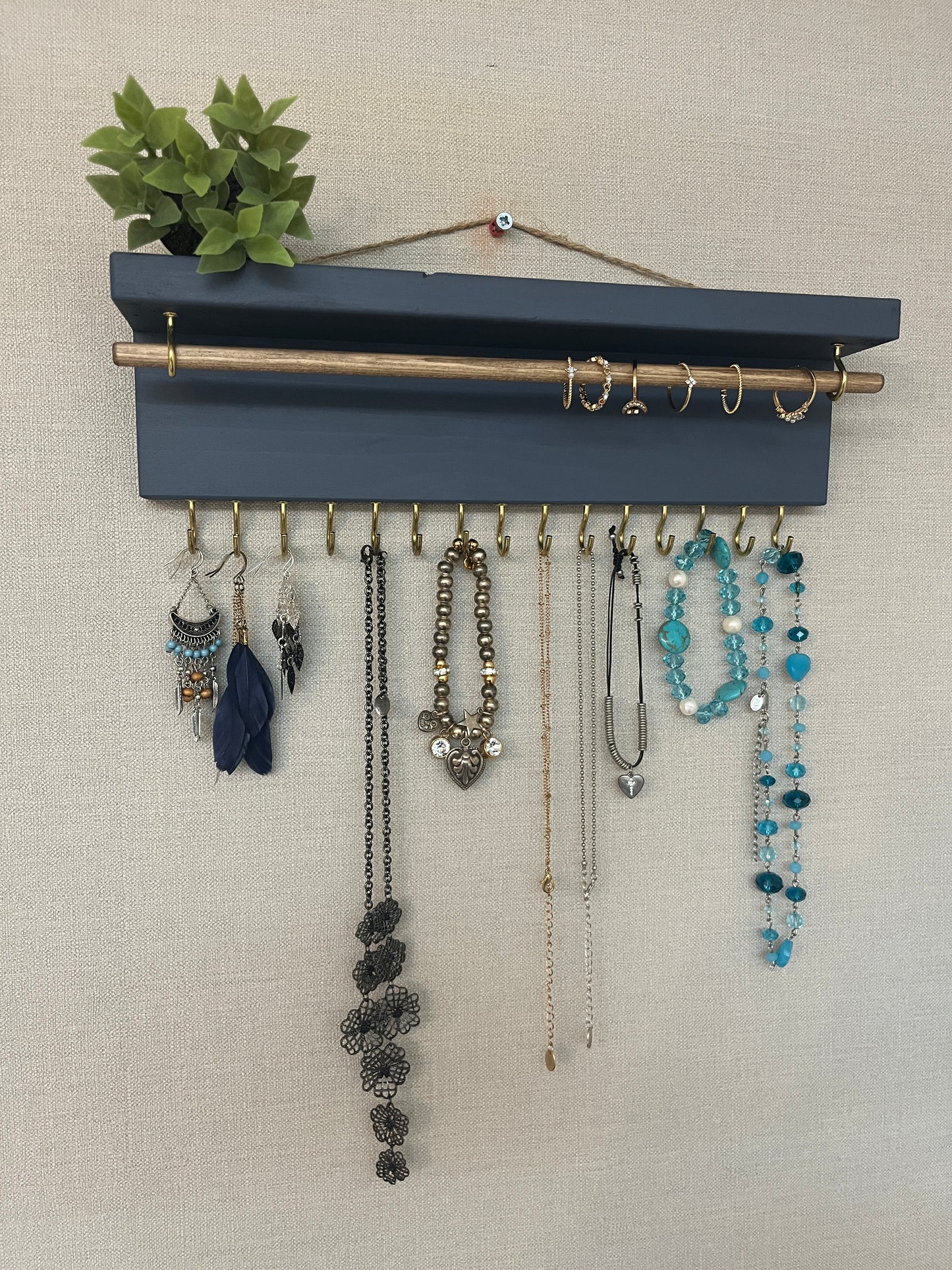 Handmade premium jewellery organizer crafted from timber, featuring 15 hooks for rings, necklaces, earrings, and bracelets. Top shelf for small items. Compact design, easy to hang, customizable color. Perfect gift for fashion lovers.