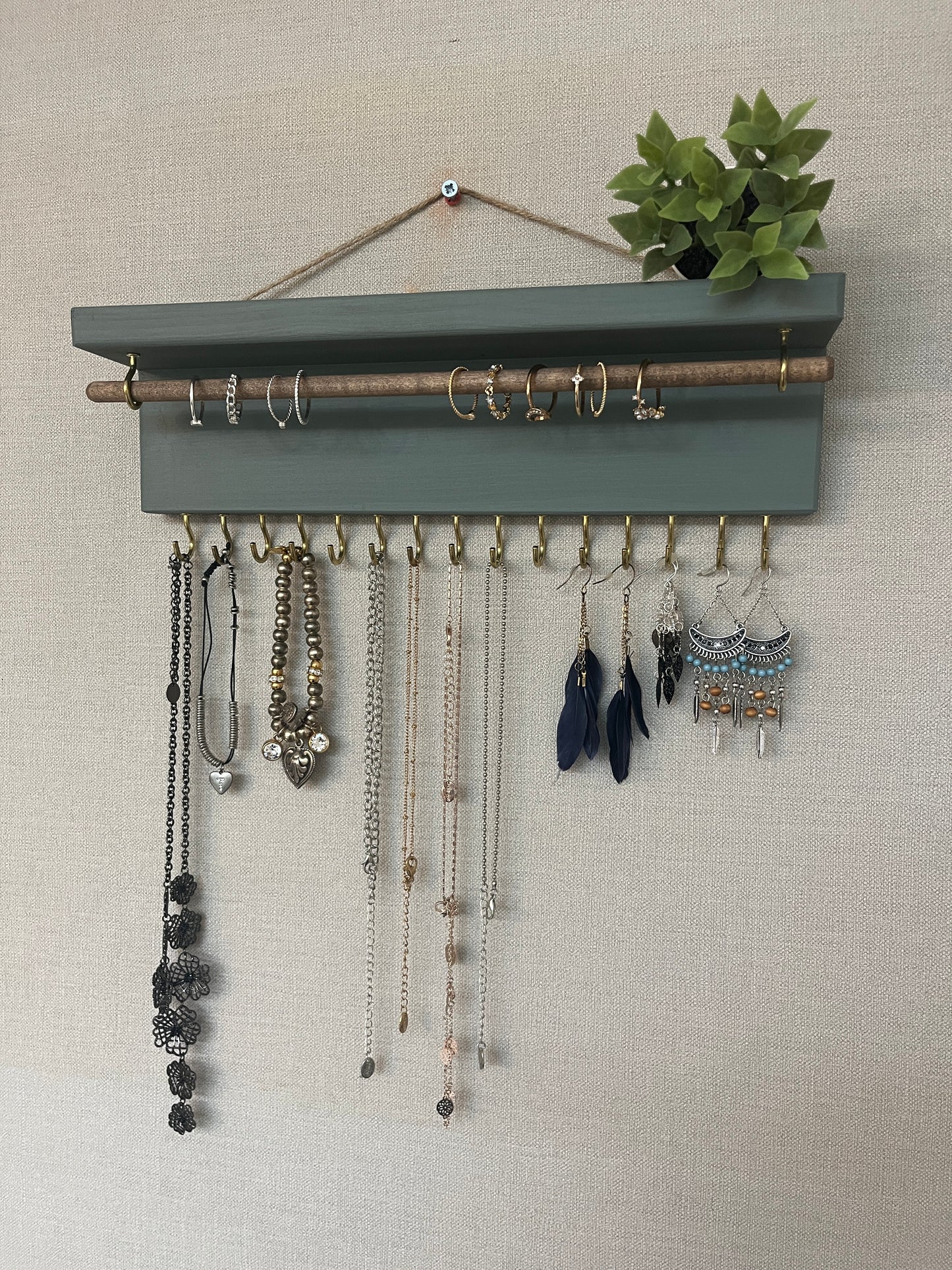 Handmade premium jewellery organizer crafted from timber, featuring 15 hooks for rings, necklaces, earrings, and bracelets. Top shelf for small items. Compact design, easy to hang, customizable color. Perfect gift for fashion lovers.