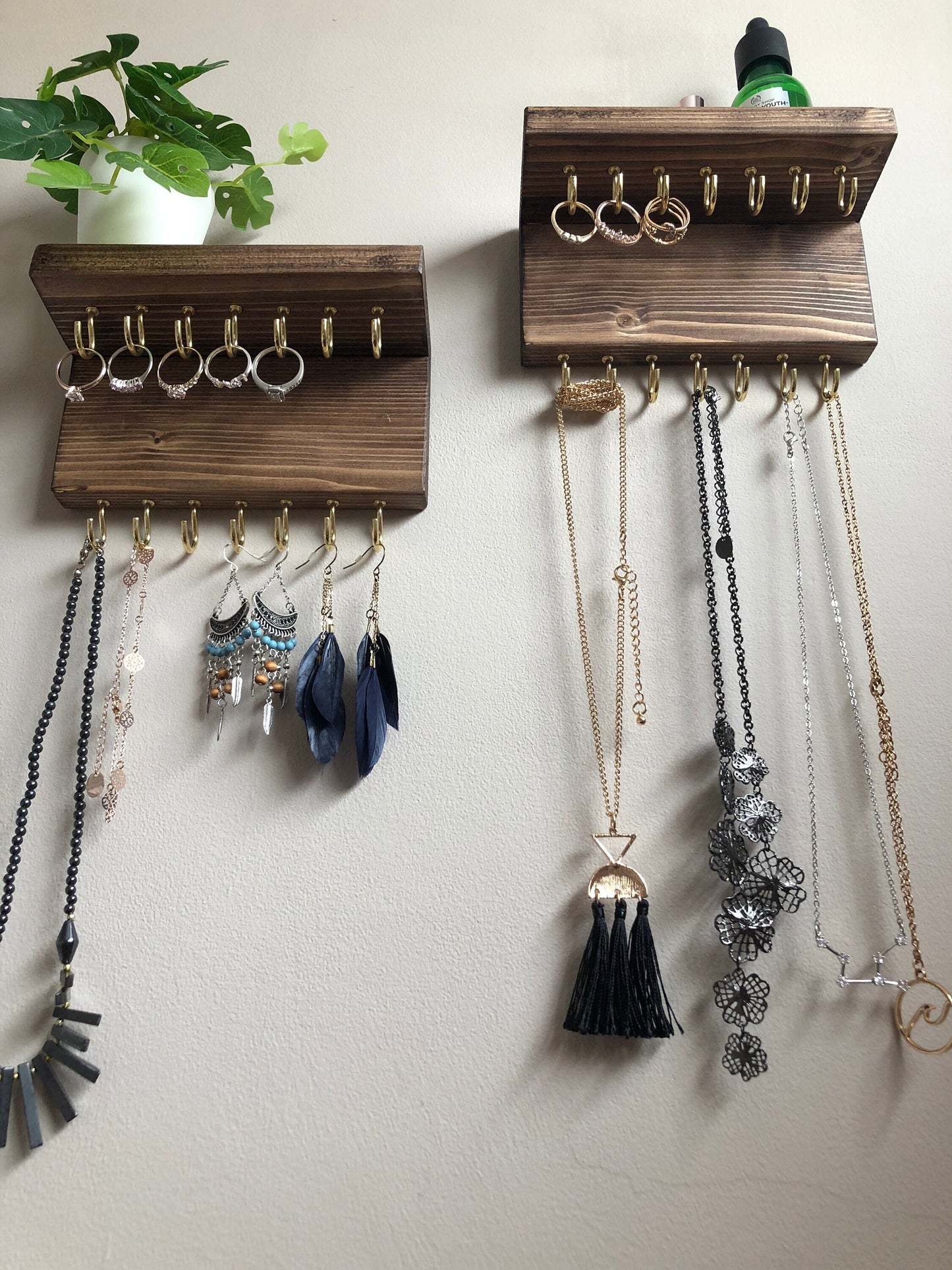 Each organizer, measuring 16cm in length, provides compact storage adaptable to any wall space, boasting a total of 28 hooks for ample room to elegantly display your favorite pieces. Featuring convenient D rings for easy hanging, these organizers double as additional shelving, perfect for storing smaller accessories. Handcrafted from carefully selected timber, each piece exudes natural charm with unique grain patterns, available in enchanting colors like Woodland, Rustic Oak, and Ebony.