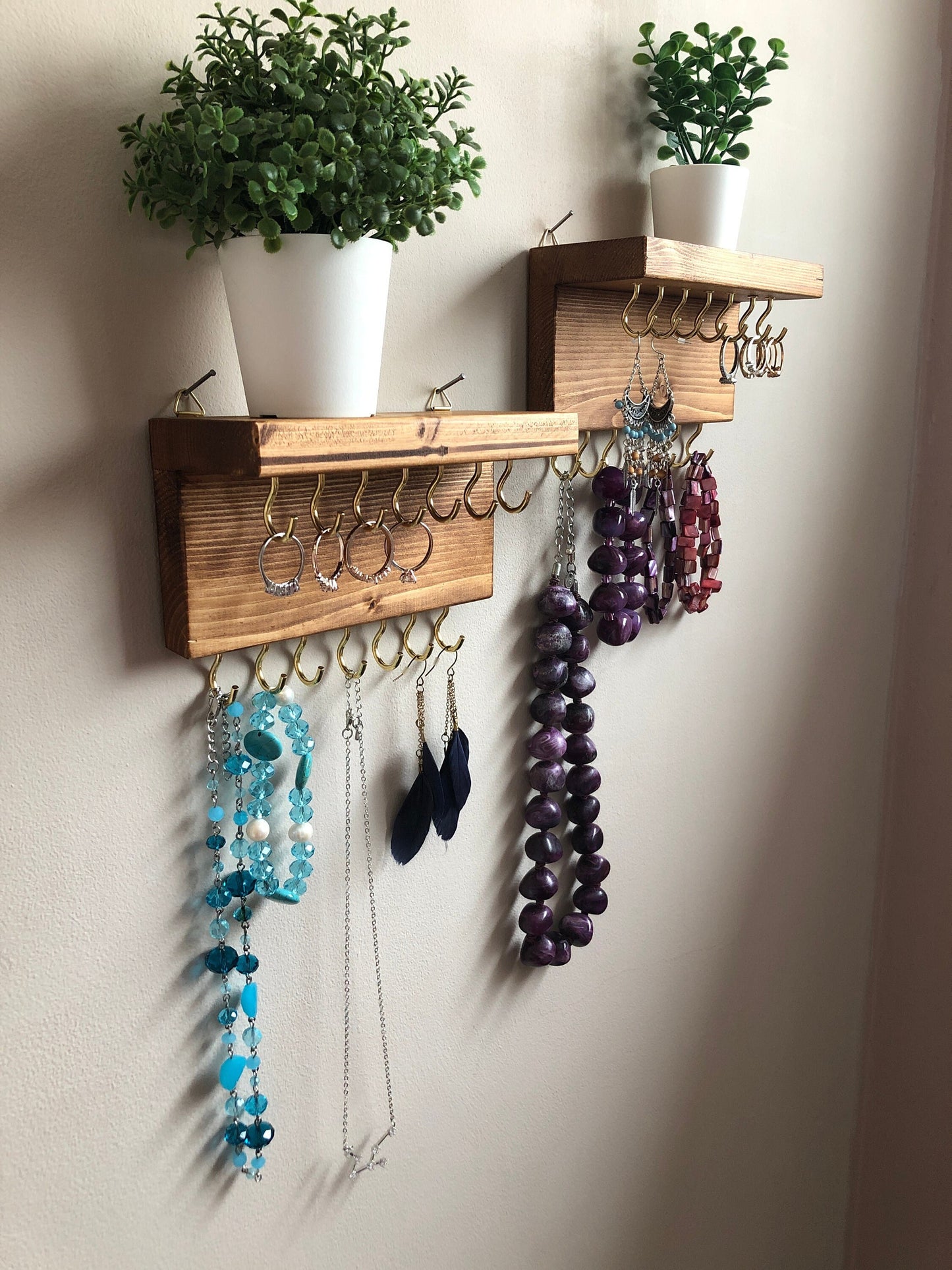Each organizer, measuring 16cm in length, provides compact storage adaptable to any wall space, boasting a total of 28 hooks for ample room to elegantly display your favorite pieces. Featuring convenient D rings for easy hanging, these organizers double as additional shelving, perfect for storing smaller accessories. Handcrafted from carefully selected timber, each piece exudes natural charm with unique grain patterns, available in enchanting colors like Woodland, Rustic Oak, and Ebony.