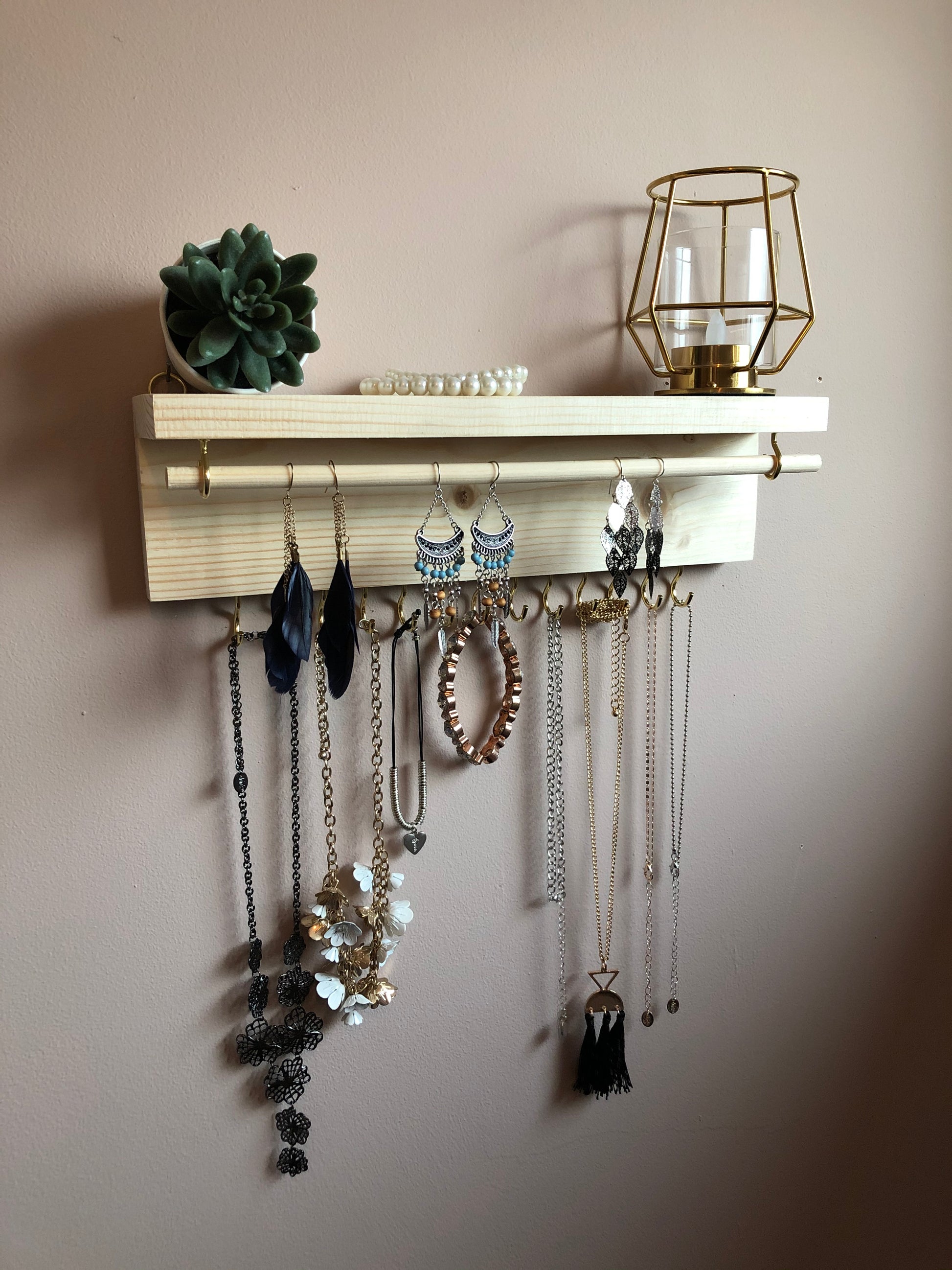  Handmade Wooden Jewellery Organiser and Earring Display featuring 13 brass hooks and a 9mm wooden dowel for versatile storage. Sleek Dark Walnut stain enhances its timeless elegance. Customize with brass or upgrade to silver/chrome hooks and D rings. Accessorize your decor effortlessly.