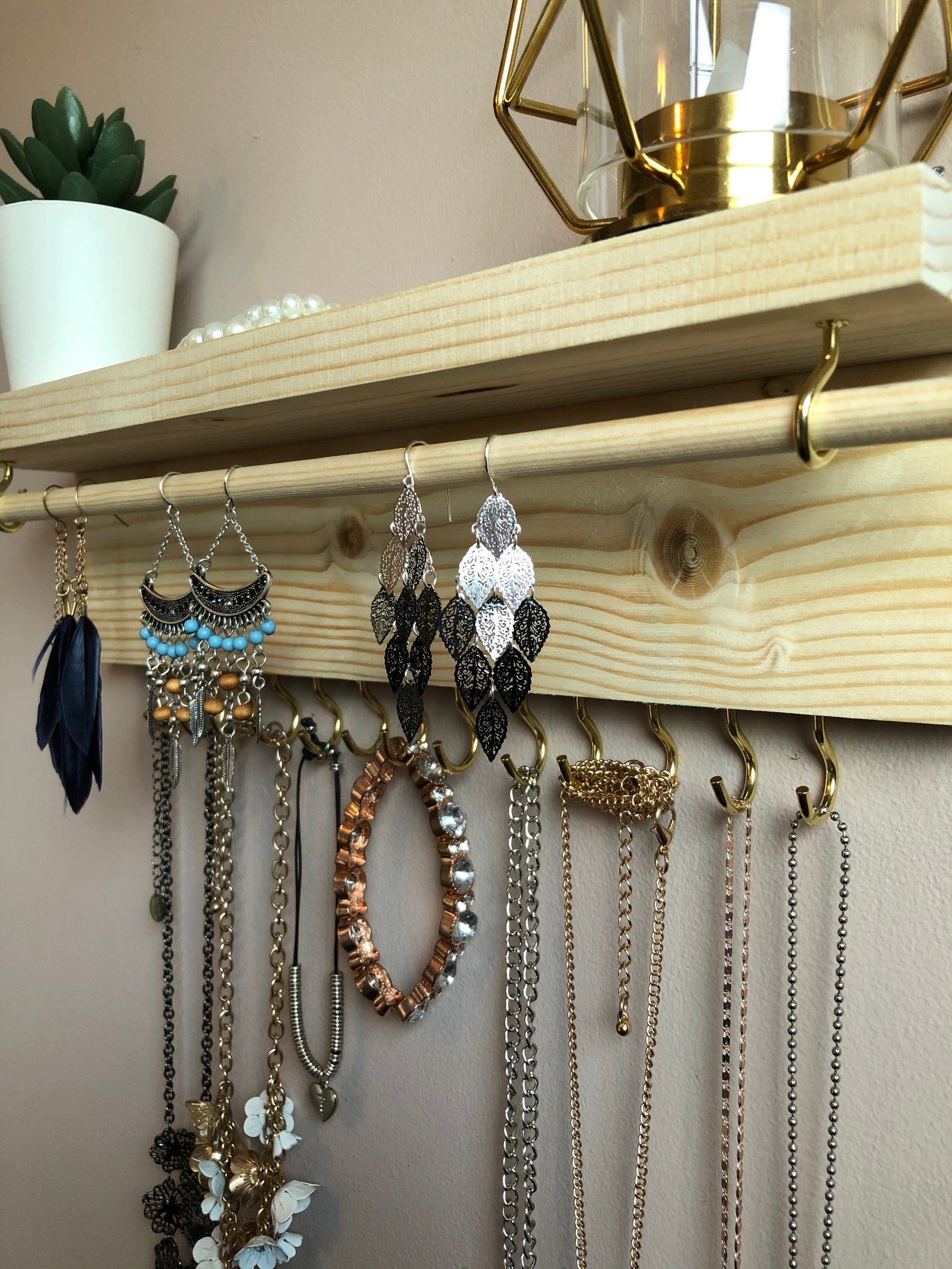  Handmade Wooden Jewellery Organiser and Earring Display featuring 13 brass hooks and a 9mm wooden dowel for versatile storage. Sleek Dark Walnut stain enhances its timeless elegance. Customize with brass or upgrade to silver/chrome hooks and D rings. Accessorize your decor effortlessly.