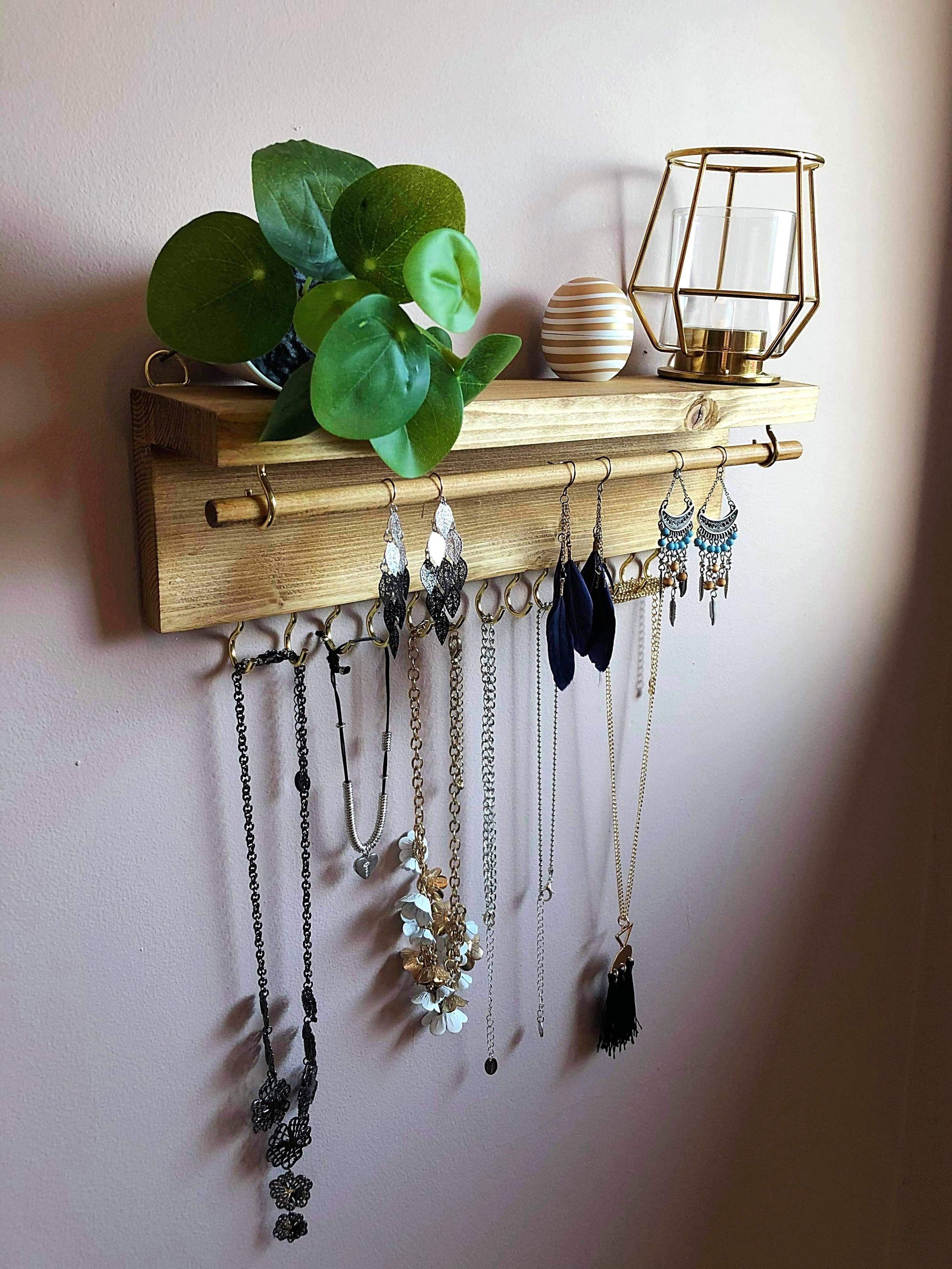  Handmade Wooden Jewellery Organiser and Earring Display featuring 13 brass hooks and a 9mm wooden dowel for versatile storage. Sleek Dark Walnut stain enhances its timeless elegance. Customize with brass or upgrade to silver/chrome hooks and D rings. Accessorize your decor effortlessly.