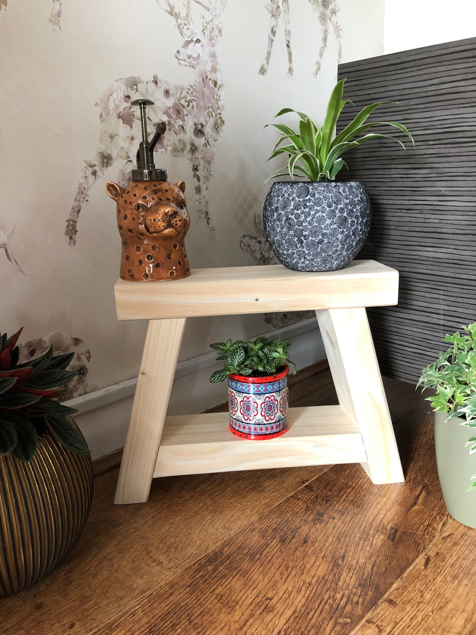 Handmade small rustic-style display stool with chunky shelves, perfect for living rooms, kitchens, and bathrooms. Ideal for house plants, beauty products, cosmetics, and candles. Made to order with options of Rustic Oak, Fir Cone, or Plain Untreated finish. Measurements: Total Height 10 inches, Width 11.75 inches, Depth 3.5 inches. Crafted with care, ensuring each piece is inspected for beauty and quality.