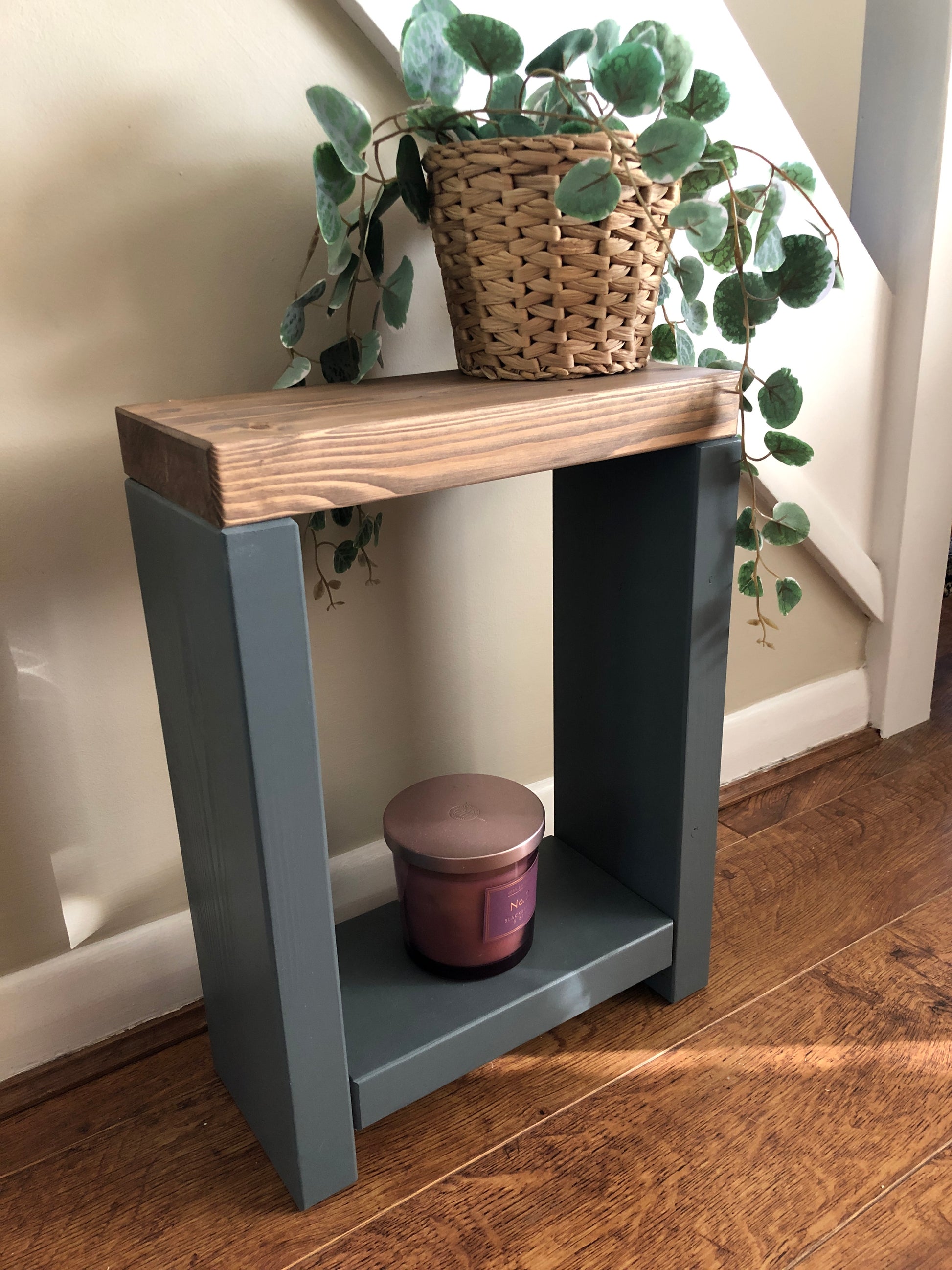 Handmade narrow side table crafted from carefully selected timber, versatile for various settings Features spacious top for plants or candles and low shelf for books or tall vase. Finished with two-tone effect: base in select Farrow and Ball colors, top in Dark Oak or Medium Oak wood dye. Dimensions: H: 44.5cm, W: 33cm, D: 14cm, with 33cm height between shelf and top. Enjoy FREE delivery on all handmade items. Order now for a carefully packaged product crafted with love. Build time: 3-4 weeks.