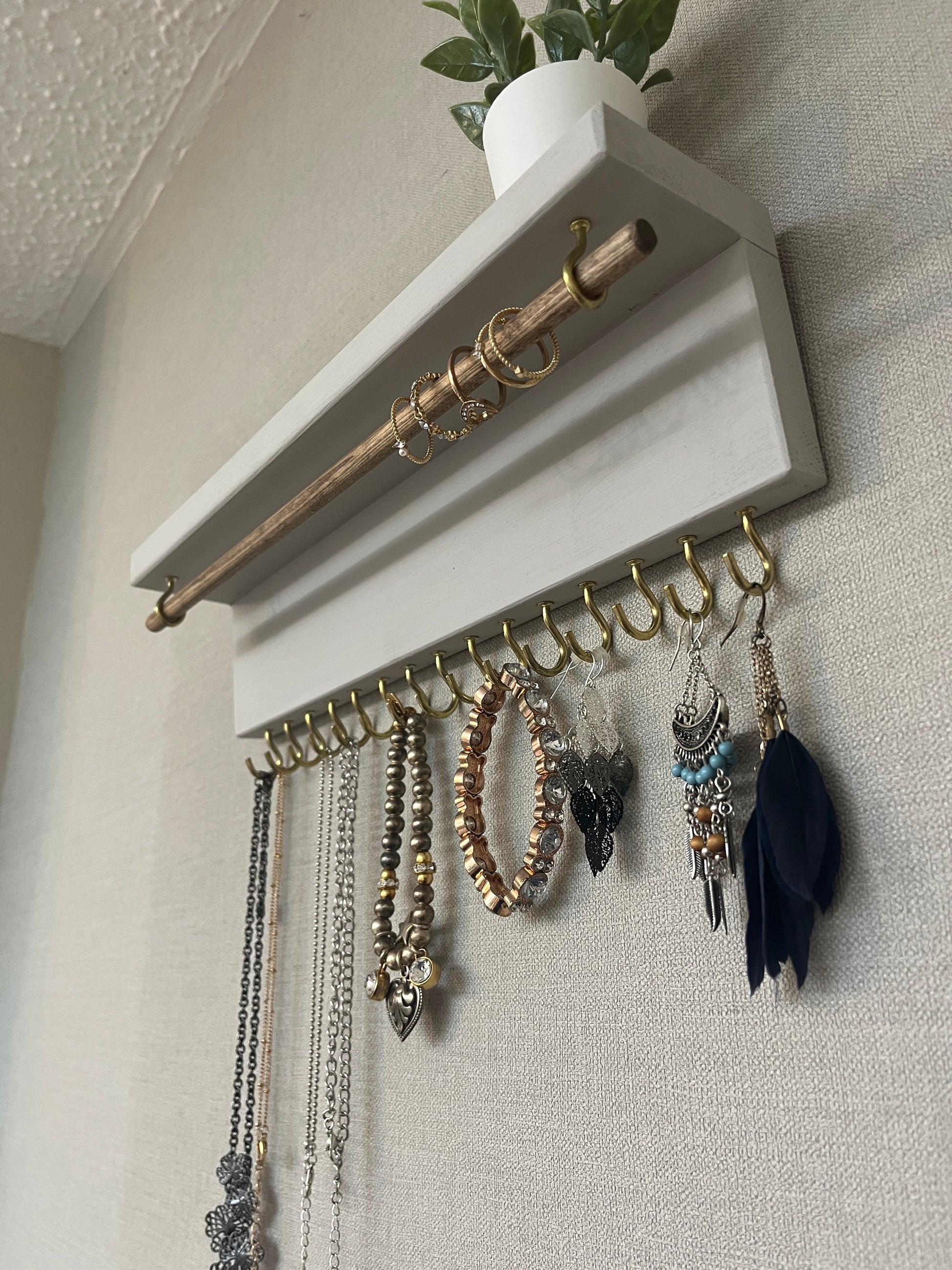Handmade premium jewellery organizer crafted from timber, featuring 15 hooks for rings, necklaces, earrings, and bracelets. Top shelf for small items. Compact design, easy to hang, customizable color. Perfect gift for fashion lovers.