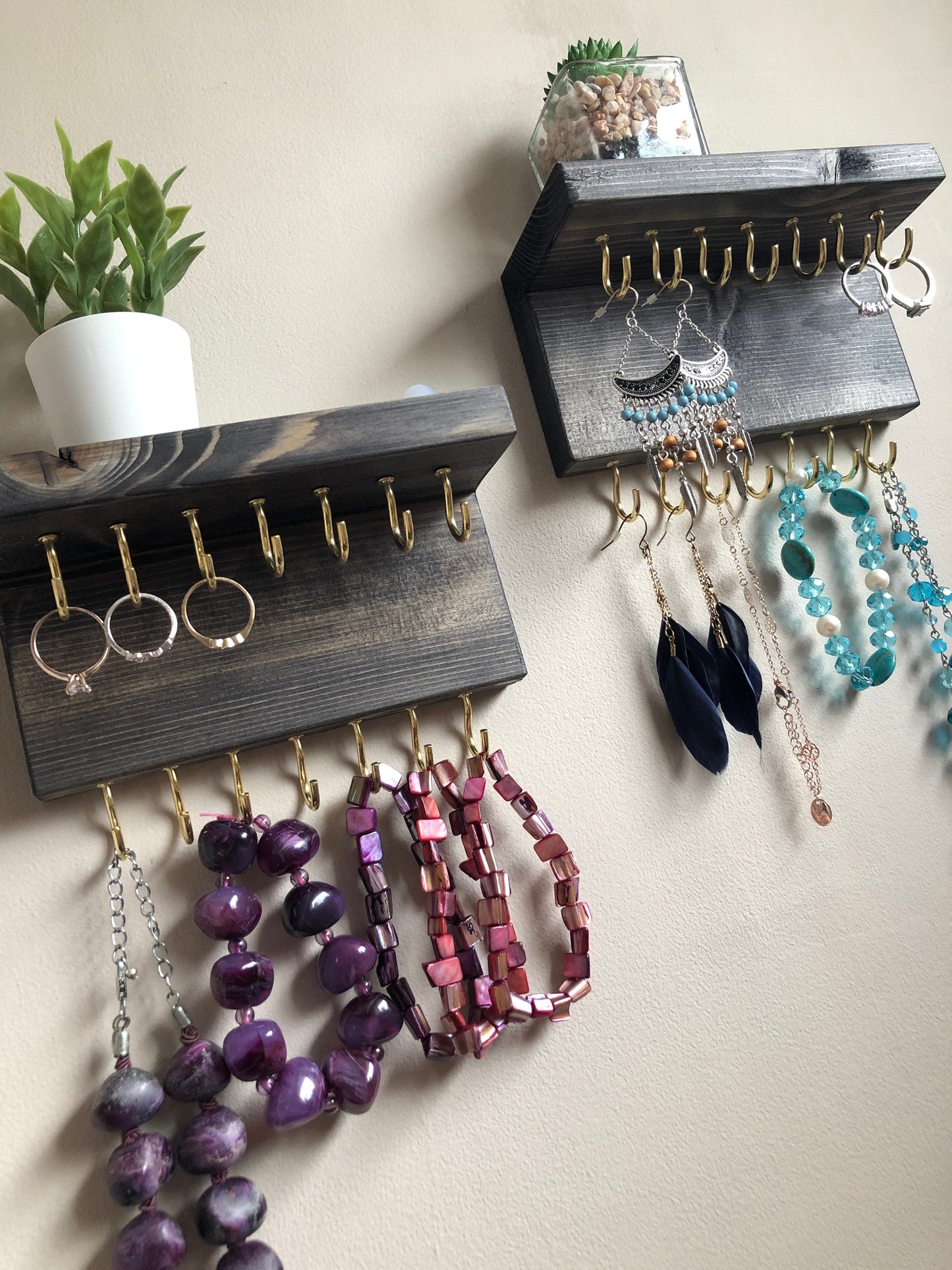 Each organizer, measuring 16cm in length, provides compact storage adaptable to any wall space, boasting a total of 28 hooks for ample room to elegantly display your favorite pieces. Featuring convenient D rings for easy hanging, these organizers double as additional shelving, perfect for storing smaller accessories. Handcrafted from carefully selected timber, each piece exudes natural charm with unique grain patterns, available in enchanting colors like Woodland, Rustic Oak, and Ebony.