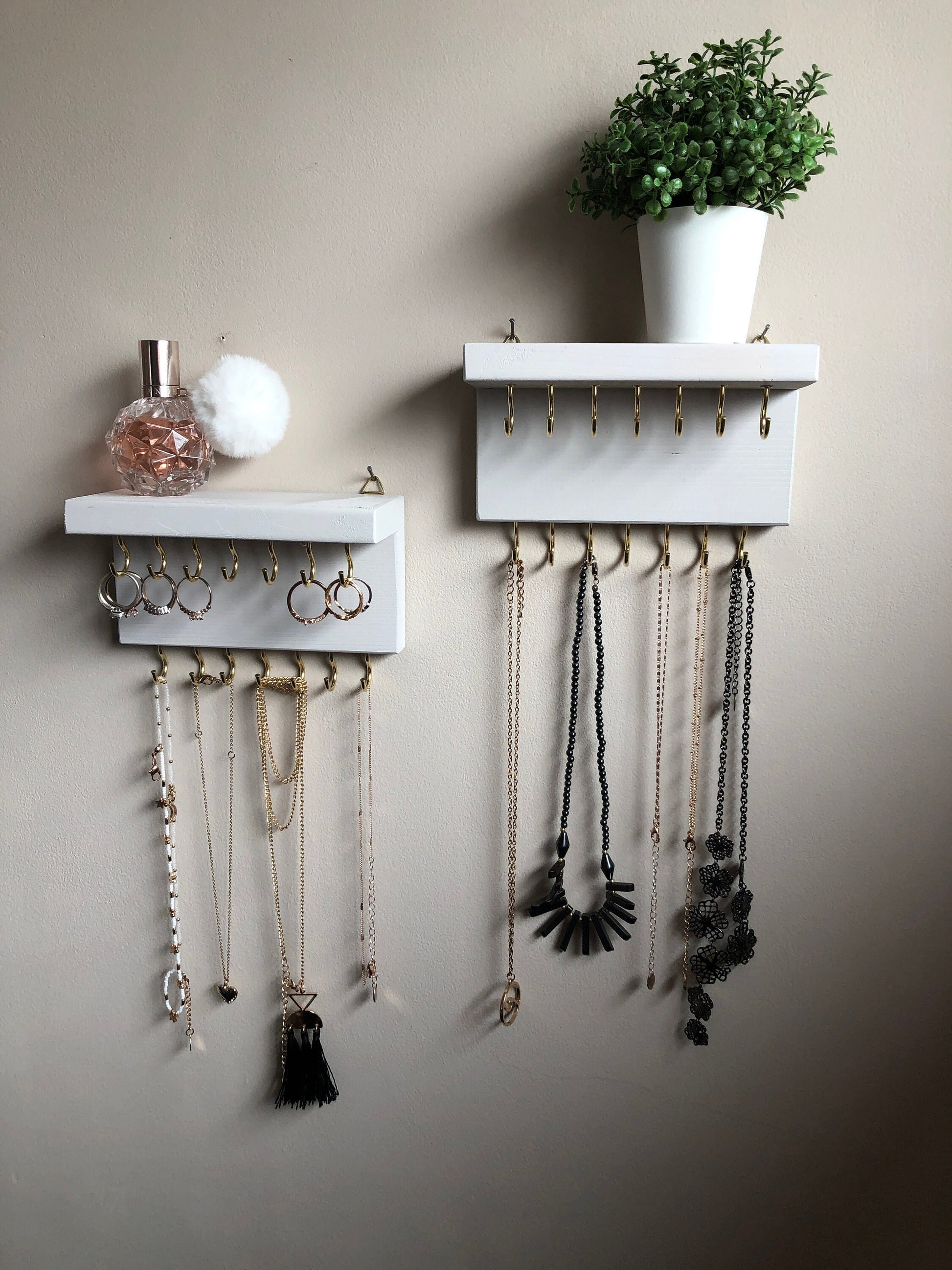 Each organizer, measuring 16cm in length, provides compact storage adaptable to any wall space, boasting a total of 28 hooks for ample room to elegantly display your favorite pieces. Featuring convenient D rings for easy hanging, these organizers double as additional shelving, perfect for storing smaller accessories. Handcrafted from carefully selected timber, each piece exudes natural charm with unique grain patterns, available in enchanting colors like Woodland, Rustic Oak, and Ebony. 