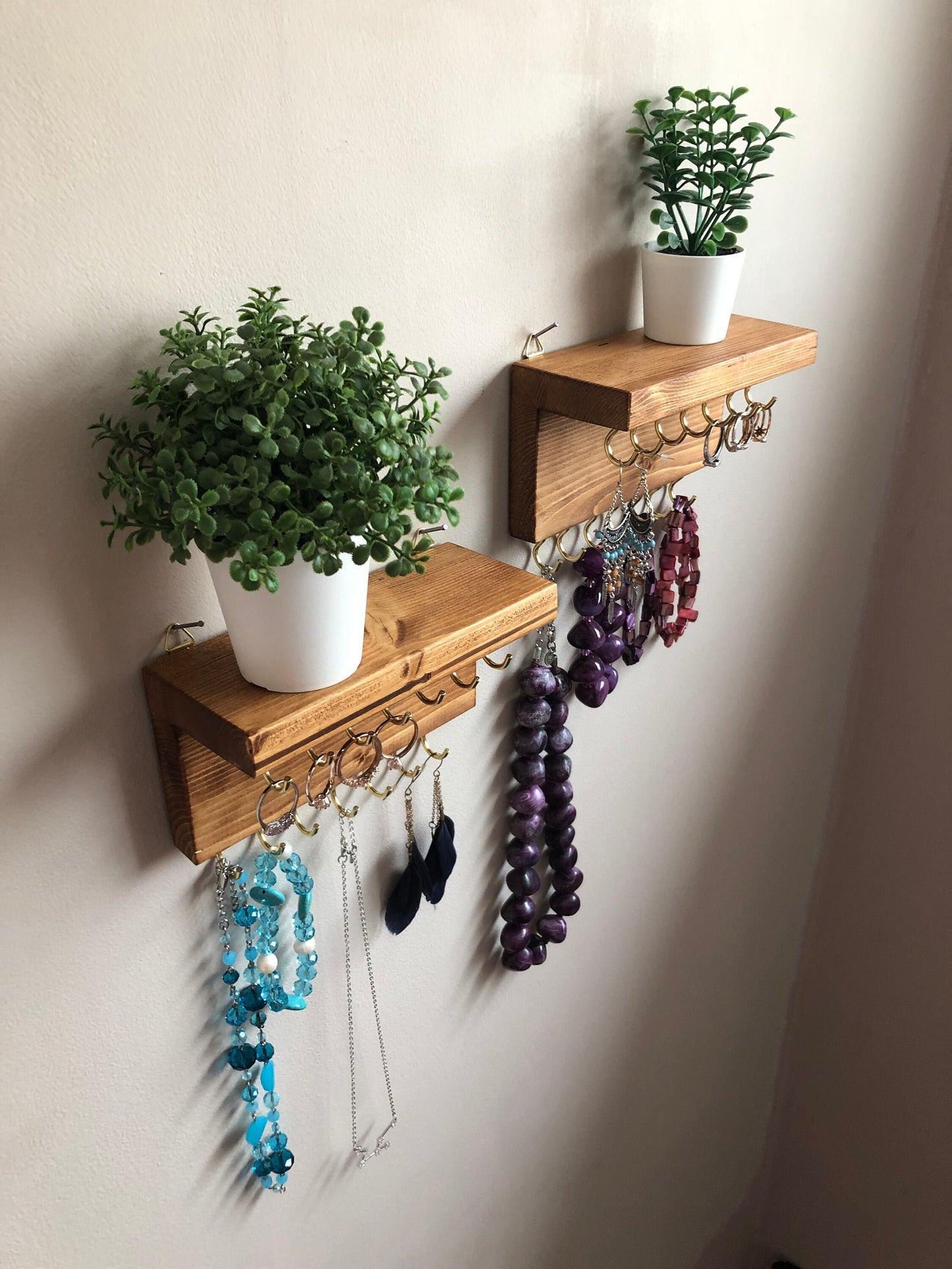 Each organizer, measuring 16cm in length, provides compact storage adaptable to any wall space, boasting a total of 28 hooks for ample room to elegantly display your favorite pieces. Featuring convenient D rings for easy hanging, these organizers double as additional shelving, perfect for storing smaller accessories. Handcrafted from carefully selected timber, each piece exudes natural charm with unique grain patterns, available in enchanting colors like Woodland, Rustic Oak, and Ebony.