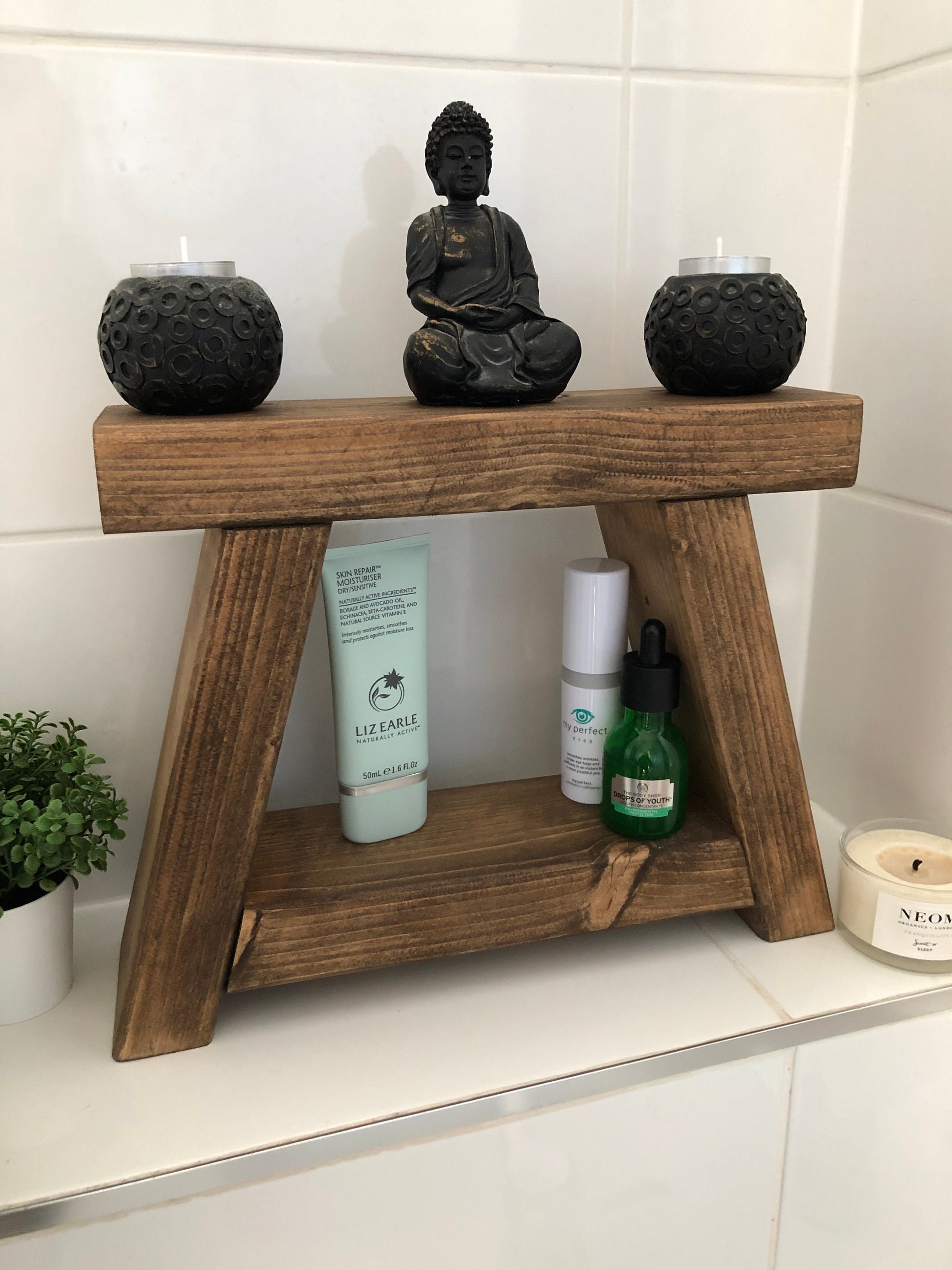 Handmade small rustic-style display stool with chunky shelves, perfect for living rooms, kitchens, and bathrooms. Ideal for house plants, beauty products, cosmetics, and candles. Made to order with options of Rustic Oak, Fir Cone, or Plain Untreated finish. Measurements: Total Height 10 inches, Width 11.75 inches, Depth 3.5 inches. Crafted with care, ensuring each piece is inspected for beauty and quality.