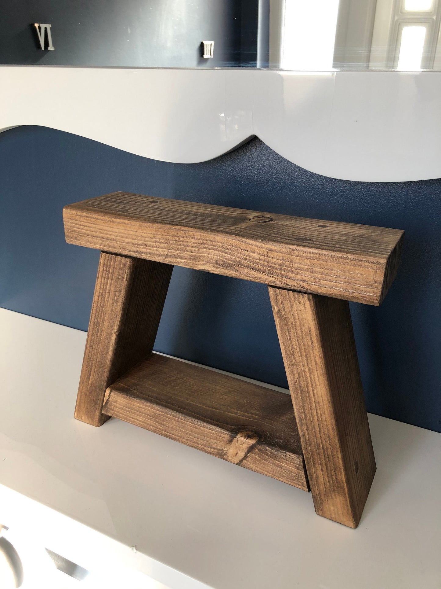 Handmade small rustic-style display stool with chunky shelves, perfect for living rooms, kitchens, and bathrooms. Ideal for house plants, beauty products, cosmetics, and candles. Made to order with options of Rustic Oak, Fir Cone, or Plain Untreated finish. Measurements: Total Height 10 inches, Width 11.75 inches, Depth 3.5 inches. Crafted with care, ensuring each piece is inspected for beauty and quality.