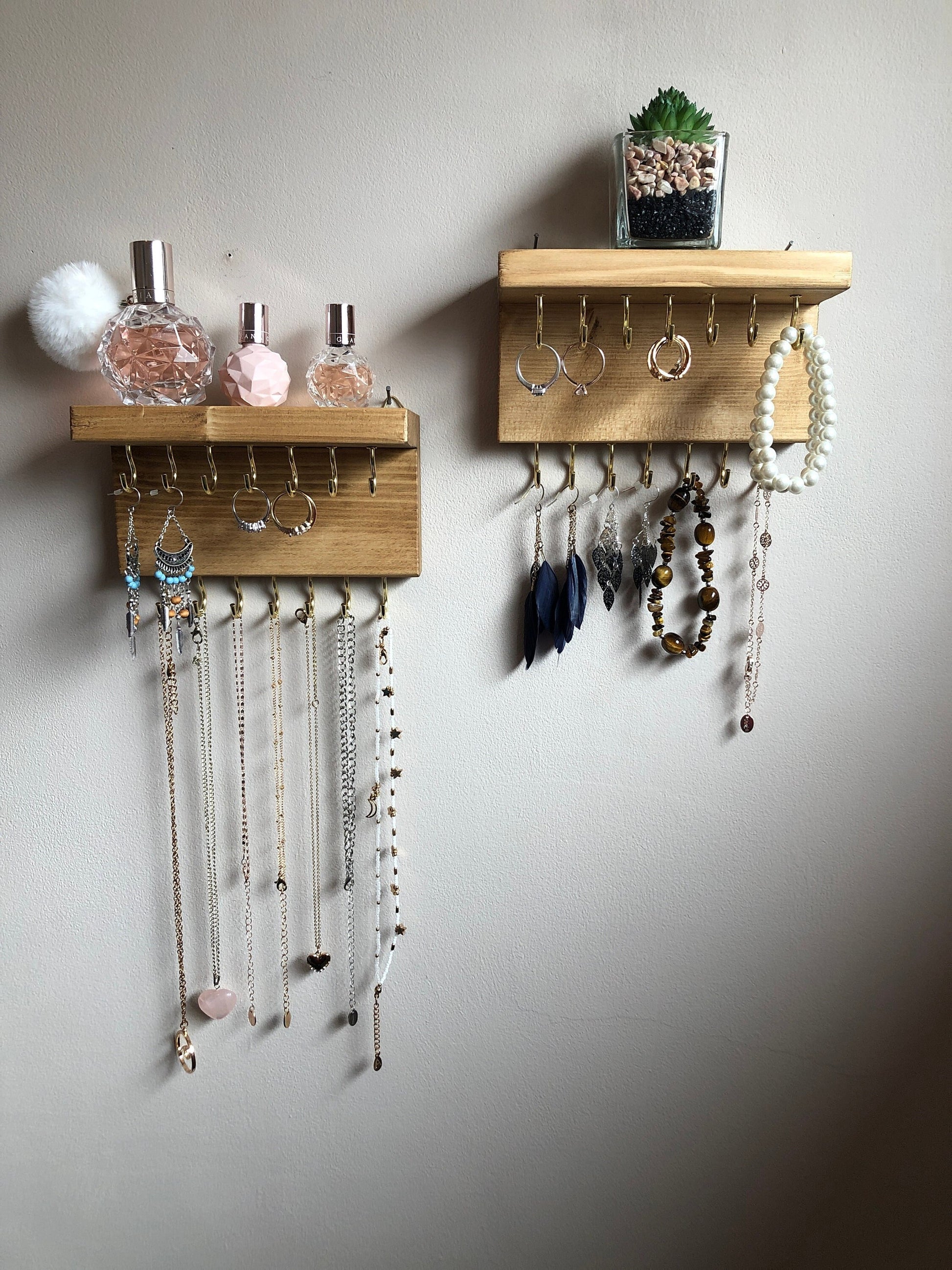 Each organizer, measuring 16cm in length, provides compact storage adaptable to any wall space, boasting a total of 28 hooks for ample room to elegantly display your favorite pieces. Featuring convenient D rings for easy hanging, these organizers double as additional shelving, perfect for storing smaller accessories. Handcrafted from carefully selected timber, each piece exudes natural charm with unique grain patterns, available in enchanting colors like Woodland, Rustic Oak, and Ebony. 