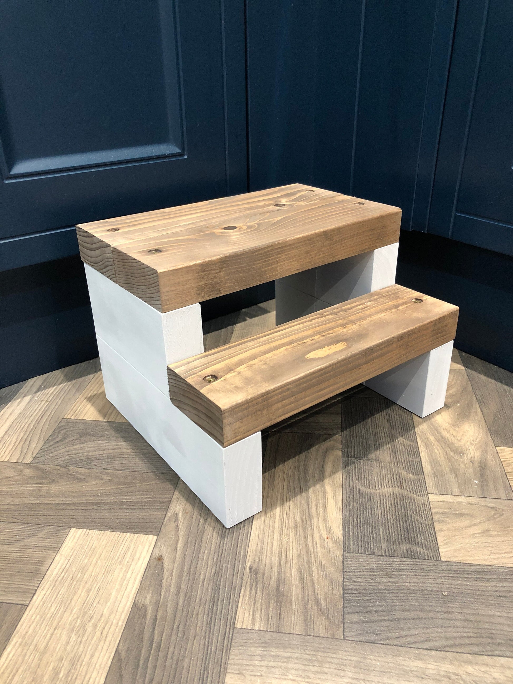 Handmade 2-tier wooden step stool, ideal for reaching high places in any room. Crafted from Scandinavian Pine with a two-tone finish. Base available in select Farrow and Ball colors. Dimensions: W: 30cm, H: 21cm, D: 26cm. Other colour options include Fresh Pine. Variations in grain and colour may occur due to the unique nature of each piece of wood