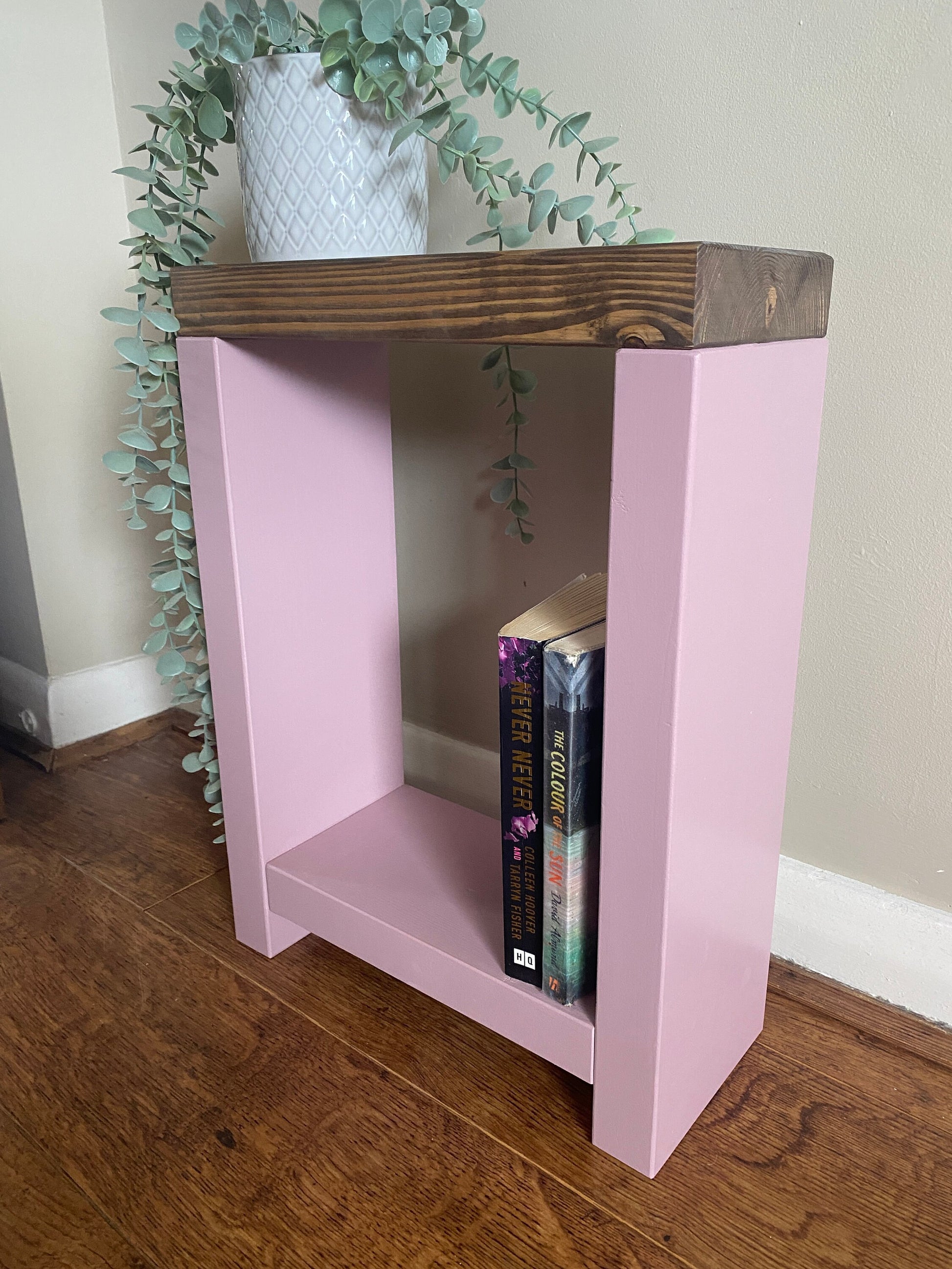 Handmade narrow side table crafted from carefully selected timber, versatile for various settings Features spacious top for plants or candles and low shelf for books or tall vase. Finished with two-tone effect: base in select Farrow and Ball colors, top in Dark Oak or Medium Oak wood dye. Dimensions: H: 44.5cm, W: 33cm, D: 14cm, with 33cm height between shelf and top. Enjoy FREE delivery on all handmade items. Order now for a carefully packaged product crafted with love. Build time: 3-4 weeks.